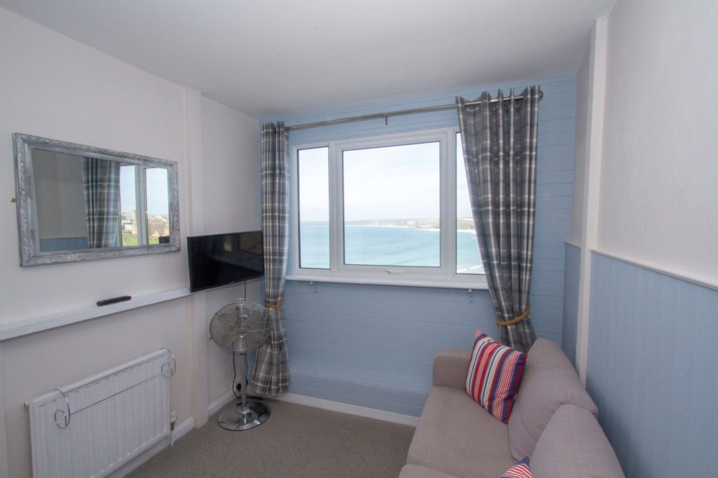 Harbour View's view, pale blue walls with sea view outside of window